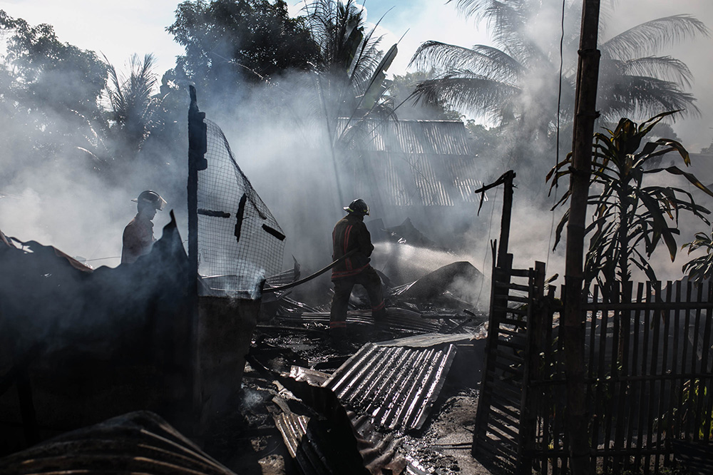 civil defense agent walks into a house ruined by fire