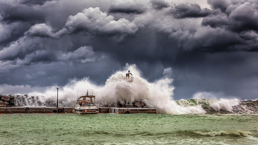 giant waves hitting a port under a severe storm